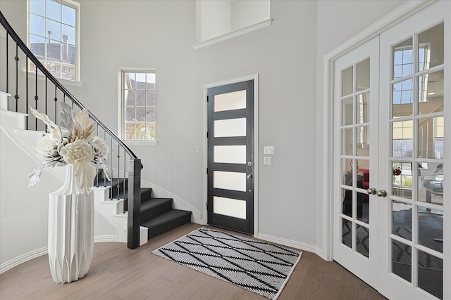 entryway with french doors, a high ceiling, and hardwood / wood-style flooring