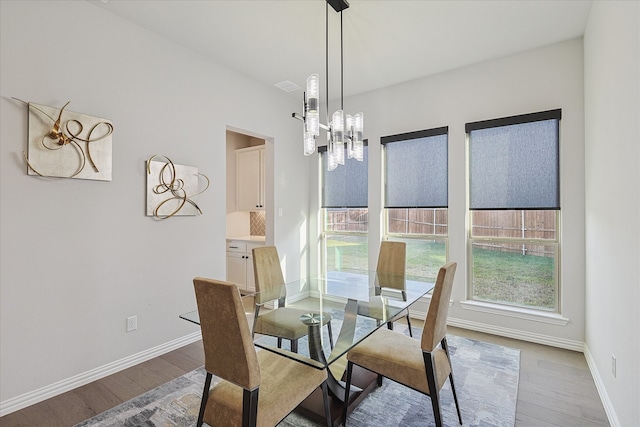 dining area with wood-type flooring and an inviting chandelier