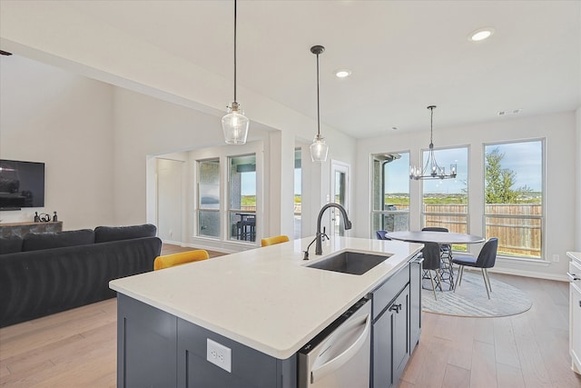 kitchen featuring dishwasher, a kitchen island with sink, sink, light hardwood / wood-style flooring, and a notable chandelier