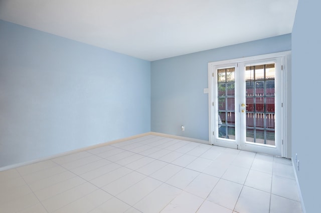 spare room with light tile patterned floors, french doors, and baseboards