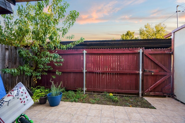 gate at dusk with a patio area