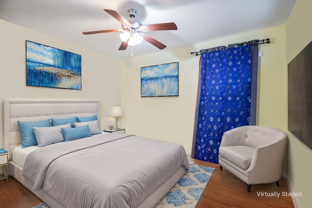 bedroom with dark hardwood / wood-style flooring and ceiling fan