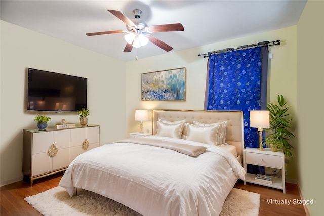 bedroom with wood finished floors, a ceiling fan, and baseboards