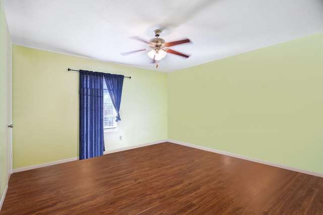 empty room featuring a ceiling fan, baseboards, and wood finished floors