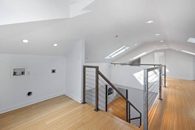 interior space featuring hardwood / wood-style floors and vaulted ceiling with skylight