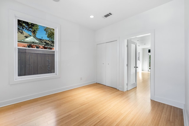 unfurnished bedroom with a closet and light hardwood / wood-style floors