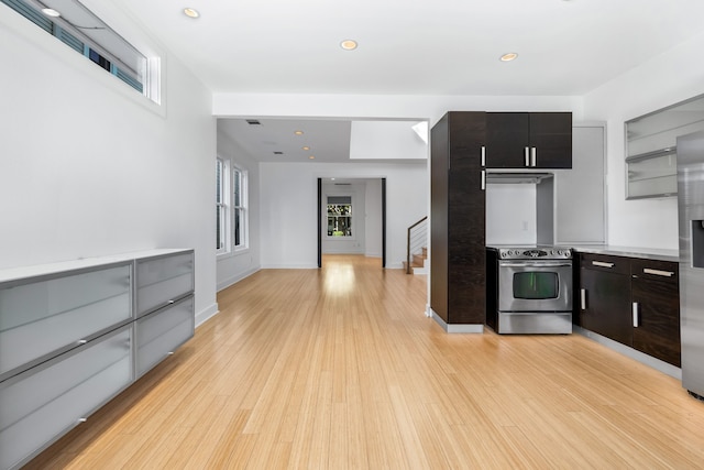 kitchen with appliances with stainless steel finishes, dark brown cabinets, and light hardwood / wood-style floors