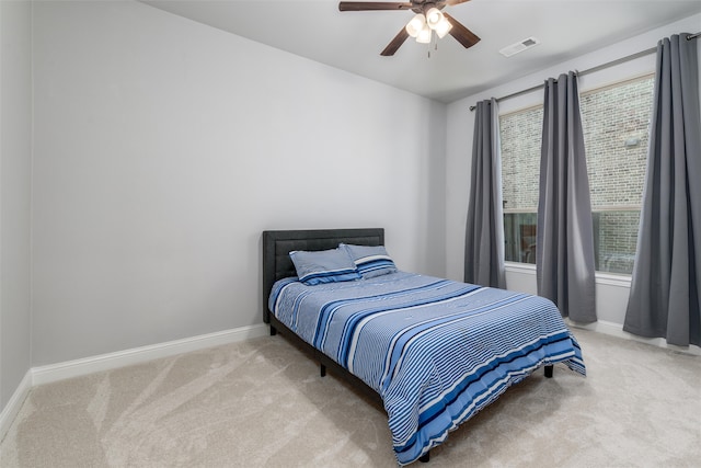 bedroom featuring ceiling fan, multiple windows, and light carpet