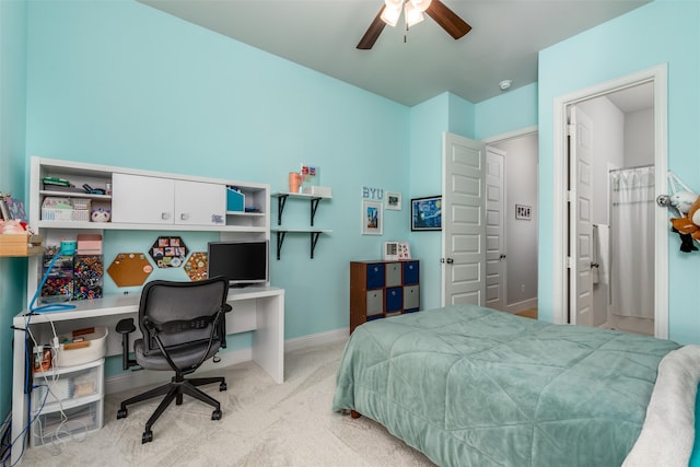 carpeted bedroom with ensuite bath and ceiling fan