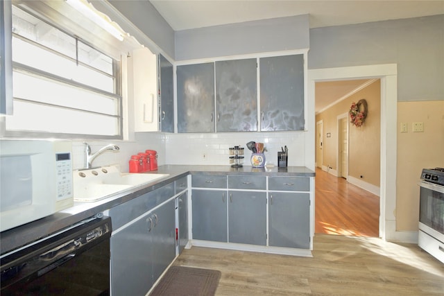 kitchen featuring sink, white appliances, light hardwood / wood-style flooring, gray cabinetry, and decorative backsplash