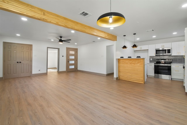 kitchen with stainless steel appliances, light hardwood / wood-style floors, decorative light fixtures, white cabinets, and decorative backsplash