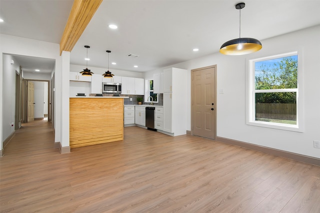 kitchen with pendant lighting, white cabinetry, light wood-type flooring, and appliances with stainless steel finishes