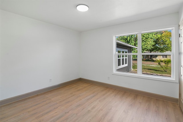 spare room featuring light hardwood / wood-style floors and a healthy amount of sunlight