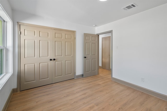 unfurnished bedroom featuring a closet and light wood-type flooring