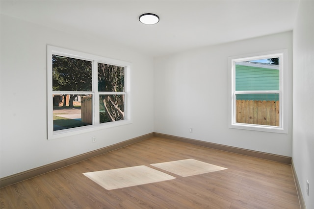 empty room featuring light wood-type flooring and a healthy amount of sunlight