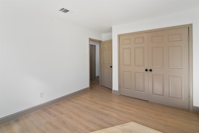 unfurnished bedroom featuring light wood-type flooring and a closet