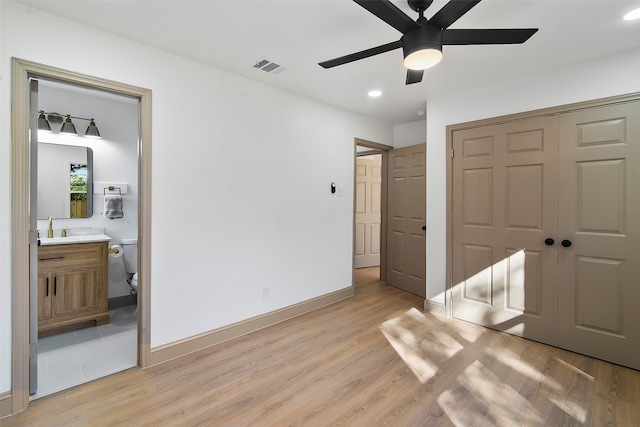 bedroom with connected bathroom, a closet, light wood-type flooring, and ceiling fan