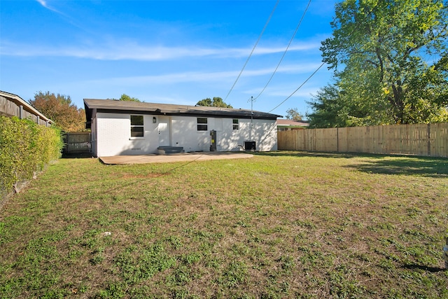 back of property with a patio area and a yard