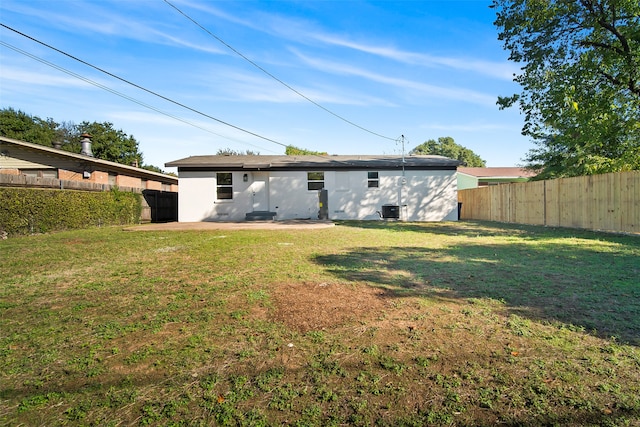 rear view of house with a patio and a yard