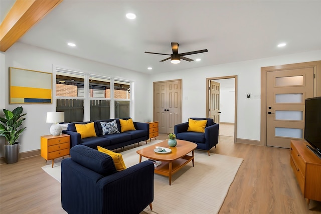 living room with beamed ceiling, ceiling fan, and light hardwood / wood-style flooring