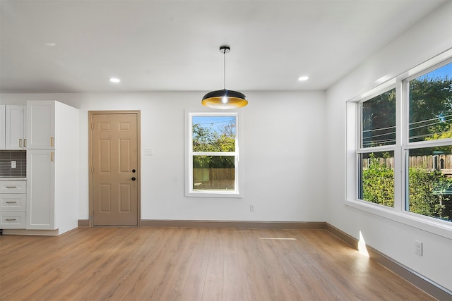 unfurnished dining area featuring a wealth of natural light and light wood-type flooring