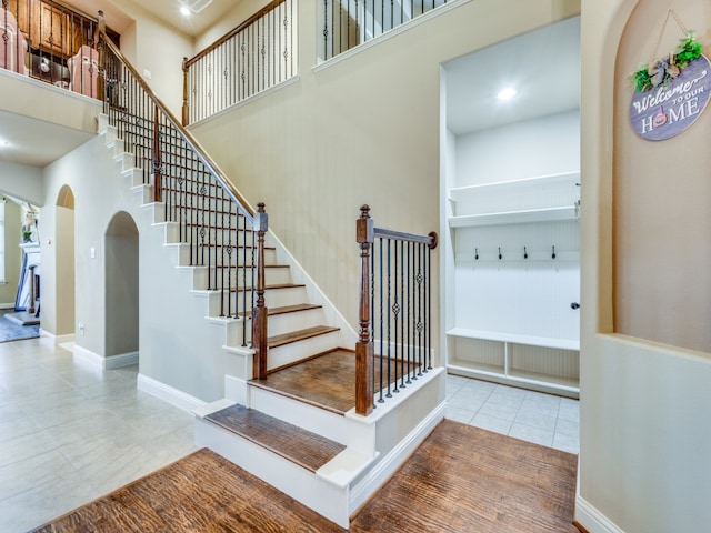 staircase with a high ceiling and tile patterned flooring