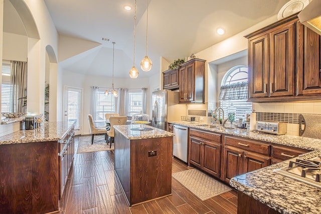 kitchen with a center island, sink, stainless steel appliances, tasteful backsplash, and dark hardwood / wood-style floors