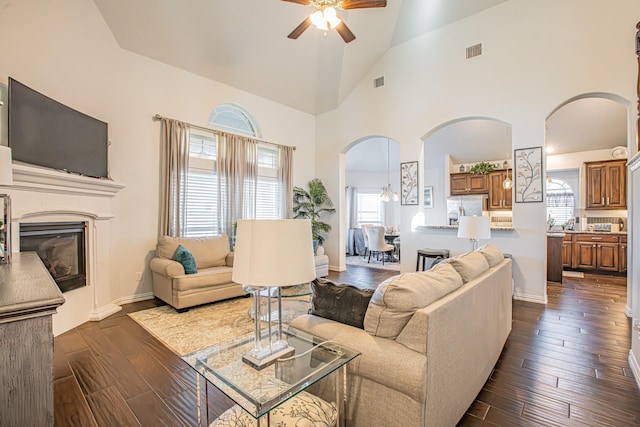 living room with ceiling fan, high vaulted ceiling, and dark hardwood / wood-style floors