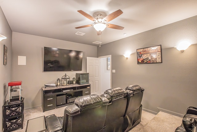 carpeted home theater room with ceiling fan