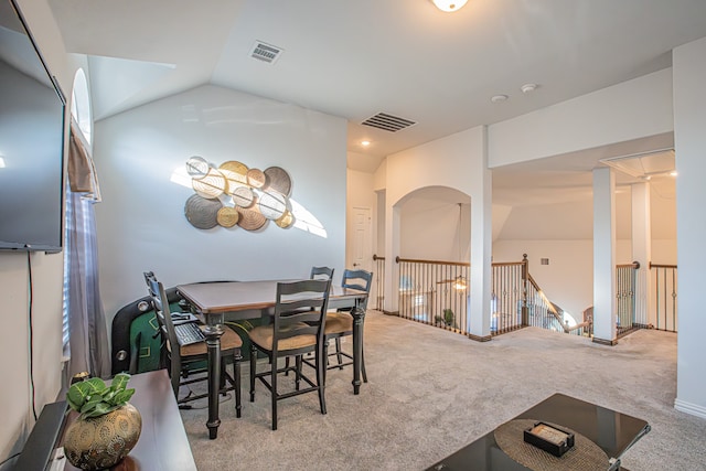 carpeted dining area with lofted ceiling