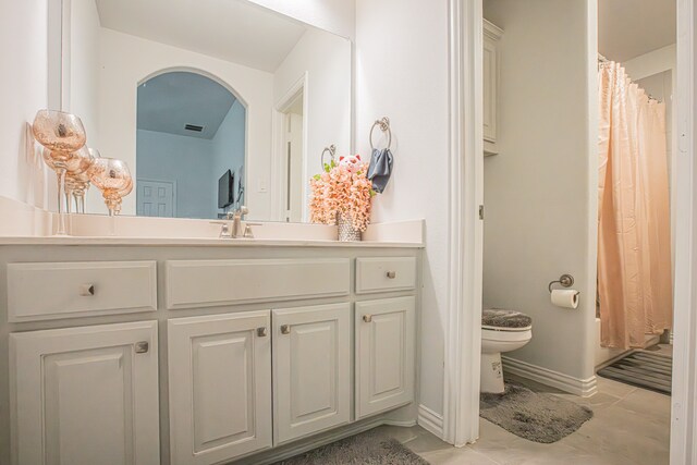 bathroom featuring tile patterned floors, vanity, and toilet