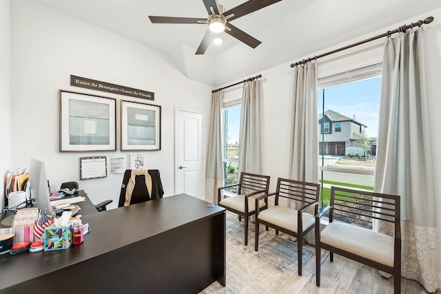 home office with a wealth of natural light, vaulted ceiling, ceiling fan, and light hardwood / wood-style flooring