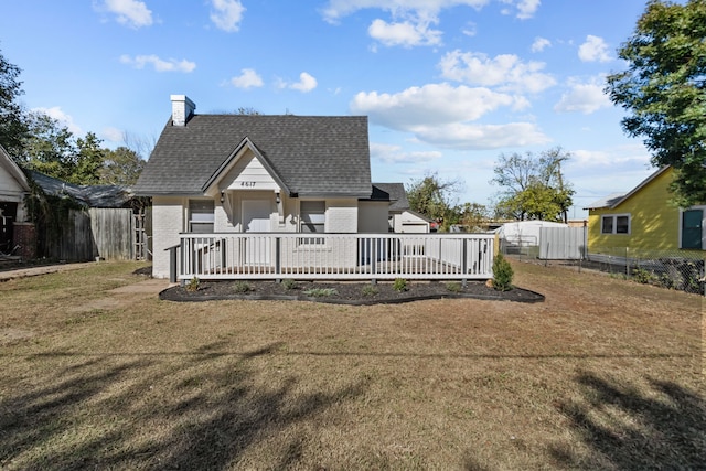 rear view of property featuring a yard and a wooden deck