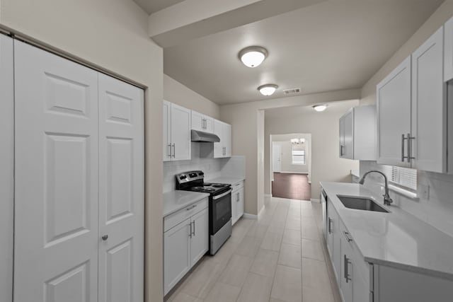 kitchen with tasteful backsplash, white cabinets, sink, and stainless steel electric stove