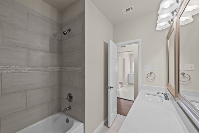 bathroom with vanity, tiled shower / bath, and tile patterned floors