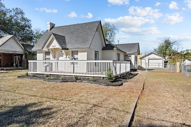 rear view of property with a lawn and an outbuilding