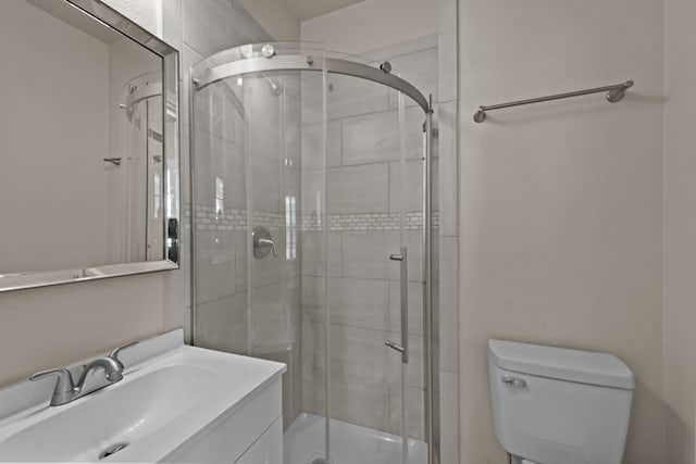 bathroom with toilet, vanity, and walk in shower