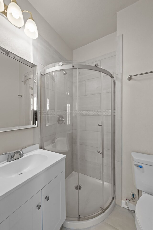 bathroom with walk in shower, vanity, and toilet