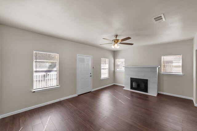 unfurnished living room featuring a fireplace, dark hardwood / wood-style floors, and ceiling fan