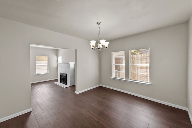 unfurnished living room featuring dark hardwood / wood-style floors and a chandelier