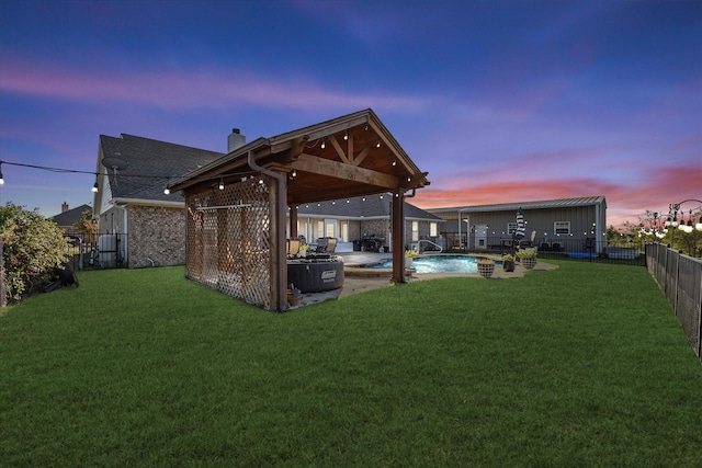 back house at dusk featuring a yard, a fenced in pool, and a patio