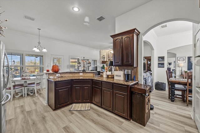 kitchen with light hardwood / wood-style floors, pendant lighting, dark brown cabinetry, and kitchen peninsula