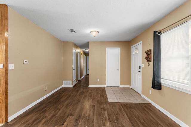 foyer with dark wood-type flooring and a textured ceiling