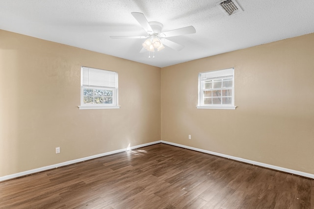 spare room with dark wood-type flooring, a textured ceiling, and ceiling fan