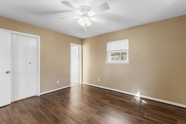 unfurnished bedroom with a textured ceiling, dark hardwood / wood-style flooring, ceiling fan, and a closet