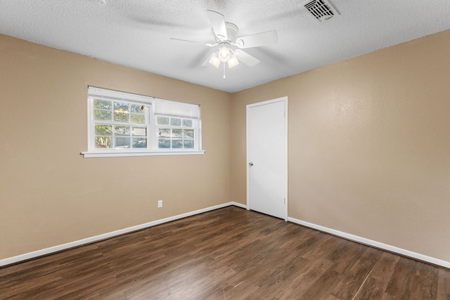 spare room with dark wood-type flooring, a textured ceiling, and ceiling fan