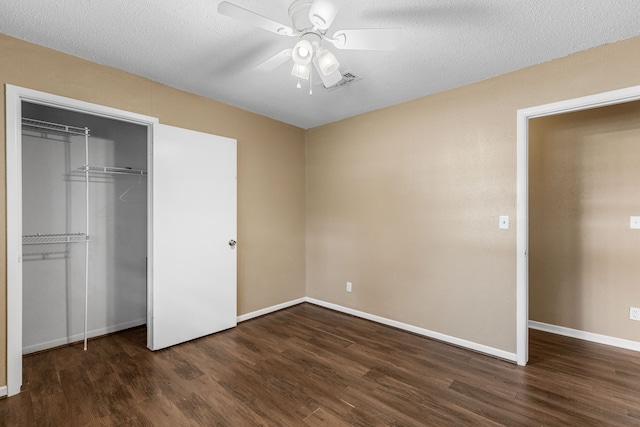 unfurnished bedroom with a textured ceiling, dark wood-type flooring, ceiling fan, and a closet