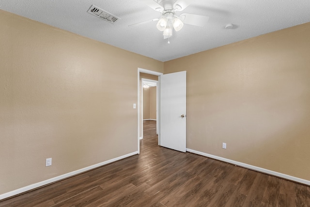 empty room featuring dark hardwood / wood-style flooring, a textured ceiling, and ceiling fan