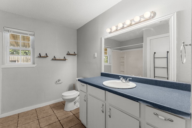 bathroom with tile patterned flooring, a textured ceiling, vanity, a shower, and toilet