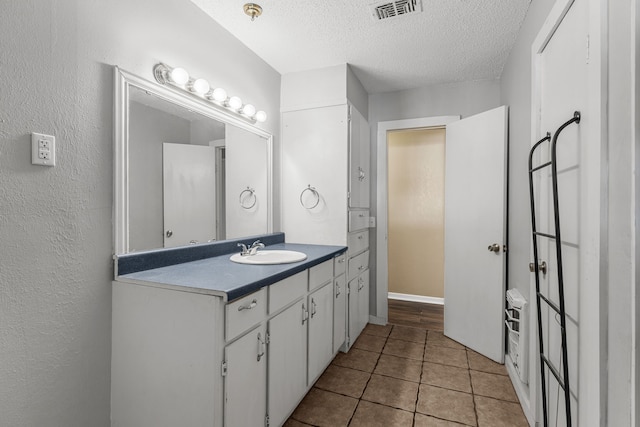 bathroom featuring vanity, tile patterned floors, and a textured ceiling